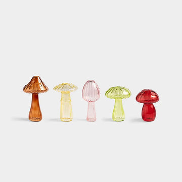 Five colorful glass mushroom-shaped objects on a white background.