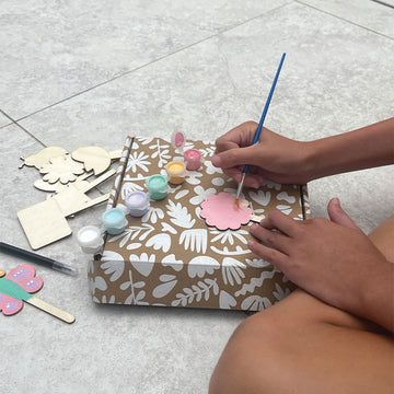 A box titled 'Paint your own plant label kit' with an illustration of labels in shapes of butterflies, birds and flower on sticks with herb names on them.