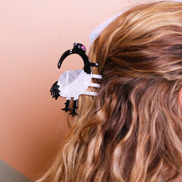 Bird-shaped hair clip with black beak and white body on a white background.