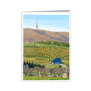 Greeting card with a scenic illustration of a landscape with hills, trees, and a building.
