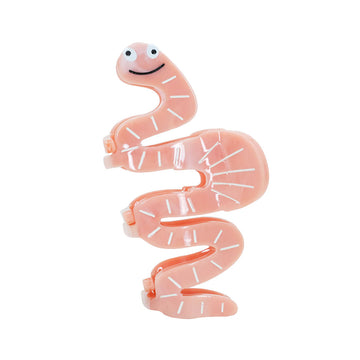 Pink worm-shaped hair clip with a face on a white background.
