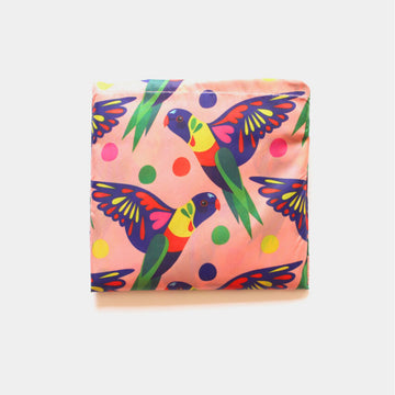 A reusable shopping bag in light orange illustrated with a repeat pattern of rainbow lorikeets.