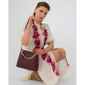 A burgundy leather bag with a short chunky gold chain strap.