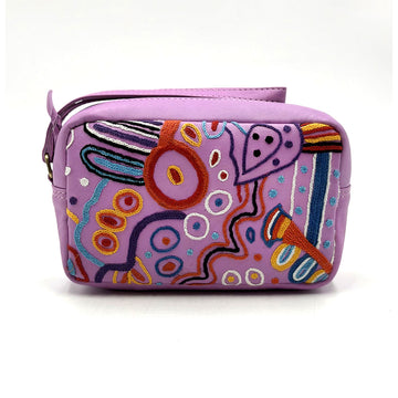 A purple leather toiletry bag embroidered with artwork by Andrea Adamson.