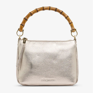 Front view of a bag with a top zipper and a gold metallic exterior with a round bamboo handle.