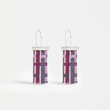 A pair of hoop earrings with a silver bar and beads hanging down making a check pattern in shades of purple.