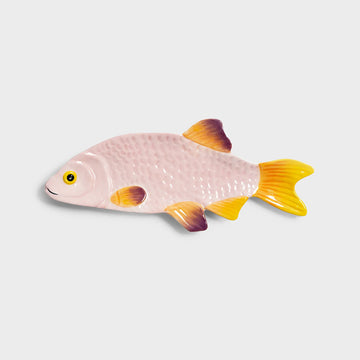 Fish-shaped ceramic plate with pink body and yellow fins on a light gray background.
