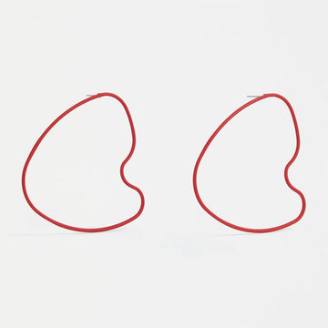 A pair of stud earrings with a large outline in red in an irregular shape.