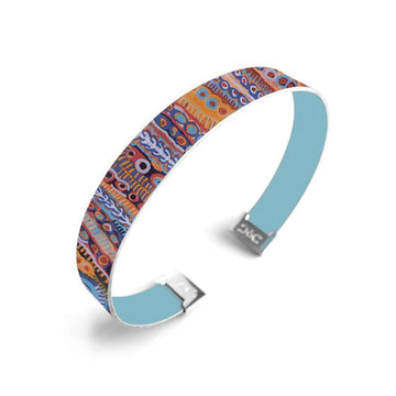 A cuff bangle printed with artwork by Murdie Morris on the outside and plain blue on the inside.