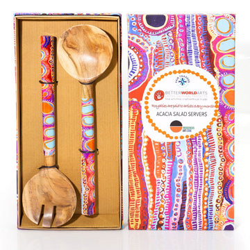 Colorful wooden salad servers with patterned handles in a box, next to their packaging.
