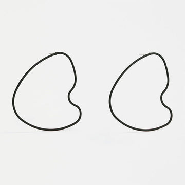 A pair of stud earrings with a large outline in black in an irregular shape.
