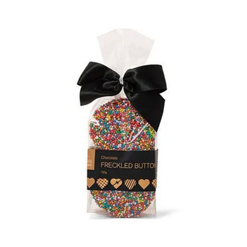 Packaged chocolate with colorful sprinkles and a black bow on a white background.
