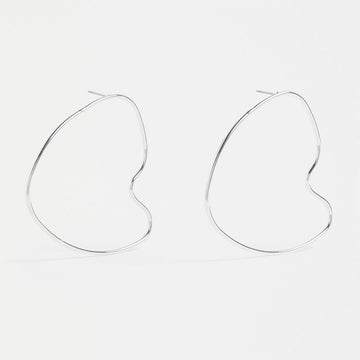 A pair of stud earrings with a large outline in silver in an irregular shape.