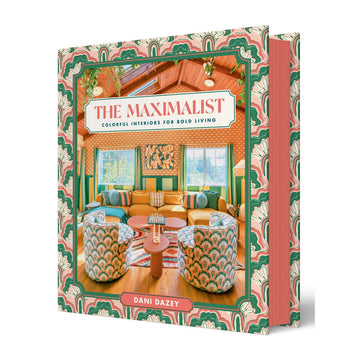 'The Maximalist' book cover featuring a photo of a brightly coloured lounge room with couches and cushions and two windows in the back.