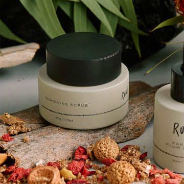 Green jar with black lid on a white background and the text 'Ruwi' on the front.