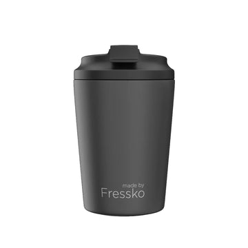 A ceramic reusable coffee cup in dark grey with a black lid and the text 'made by Fressko' on the bottom.