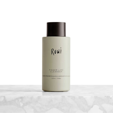 Bottle of Ruwi Finger Lime Cleanser on a marble surface with a white background.