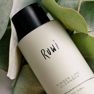 Bottle of Ruwi Finger Lime Cleanser on a marble surface with a white background.