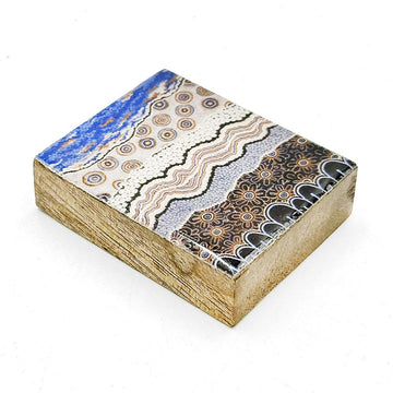 A wooden block magnet printed with artwork by Bianca Gardiner-Dodd on top.