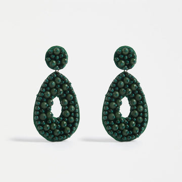 A pair of drop earrings with a circle top and tear drop bottom decorated with green beads.