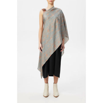 A silk scarf is being worn over a model covering half her outfit on a diagonal angle.