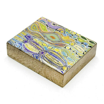 A wooden block magnet printed with artwork by Judy Watson on top.