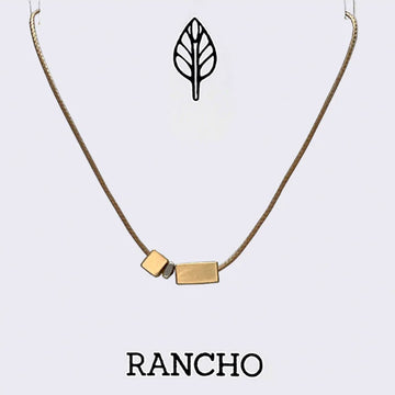 Necklace with gold pendants on a light gray background, featuring the brand 'RANCHO'.