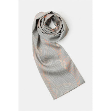 A silk scarf is rolled up with the end sticking out. The scarf is grey and printed with light grey and coral pink lines.