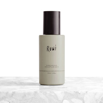 Moisturizer bottle with 'Ruwi' branding on a marble surface.