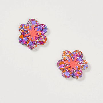 A pair of stud earrings shaped like a flower in a purple and orange glitter design.