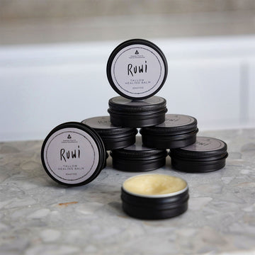 Stack of black tins labeled 'Ruwi' on a marble surface.