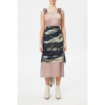 A model wears a silk scarf around her waist covering a large portion of her pink dress.