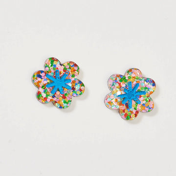 A pair of stud earrings shaped like a flower in a blue and rainbow glitter design.
