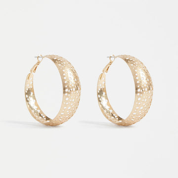 A pair of gold hoop earrings with small circle cut outs.
