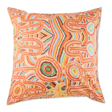 A square European cushion printed with Indigenous artwork in orange.