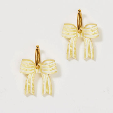 A pair of gold hoop earrings with yellow bows attached to the hoop.