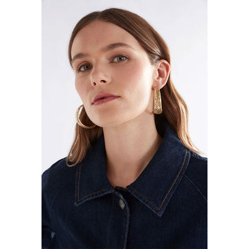 A pair of gold hoop earrings with small circle cut outs.