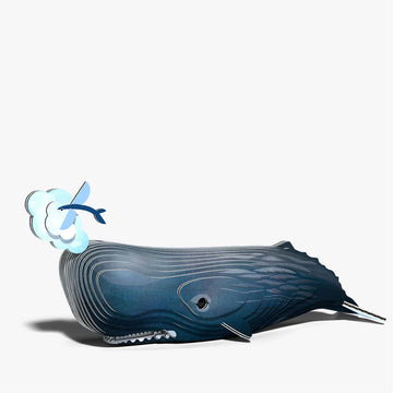 Model of a whale blowing water with a small fish nearby on a white background.