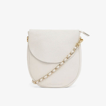 A chalk coloured pebble leather bag with a tall round shape and a gold chain strap.