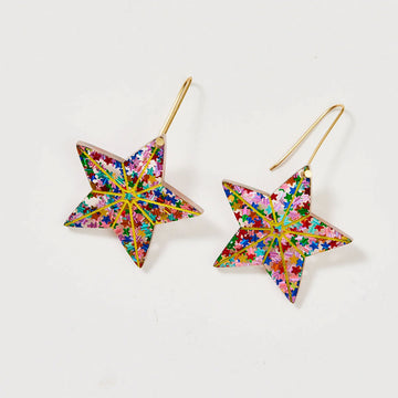 A pair of drop earrings with a star attached filled with rainbow glitter.
