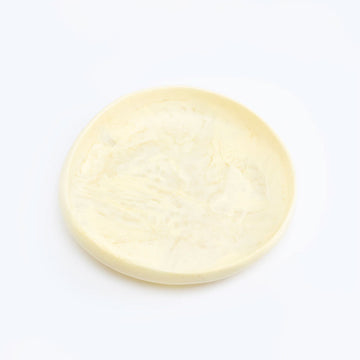 A shallow bowl made from resin with pale yellow and white swirls.