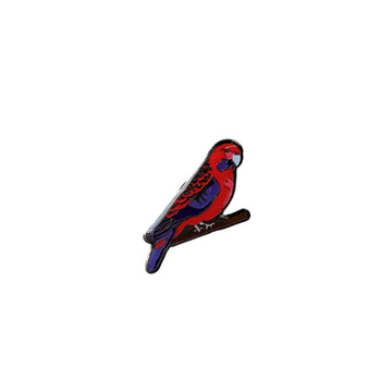 A metal badge shaped like a crimson rosella.