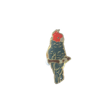 A metal badge shaped like a Gang Gang cockatoo.