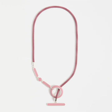 Pink necklace with a circular pendant on a light gray background.