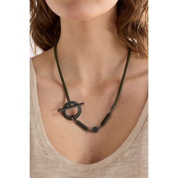 Pink necklace with a circular pendant on a light gray background.