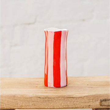 A small ceramic hand painted vase with red and pink vertical stripes.