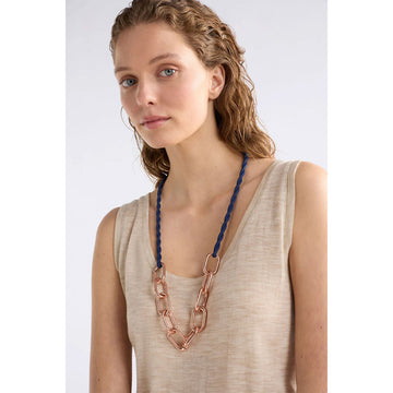 Necklace with rose gold chain and blue braided cord on a white background.