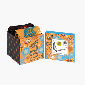 A cube box with two pairs of socks folded up inside illustrated with Aboriginal art of snakes and kangaroos.
