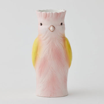 A vase shaped like a pink bird with yellow wings.