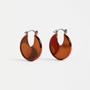 Pair of copper hoop earrings on a white background.